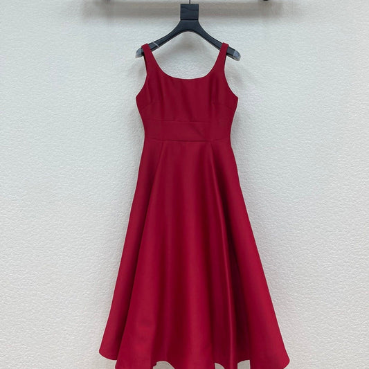 Red dress hanging on a black hanger against a white wall